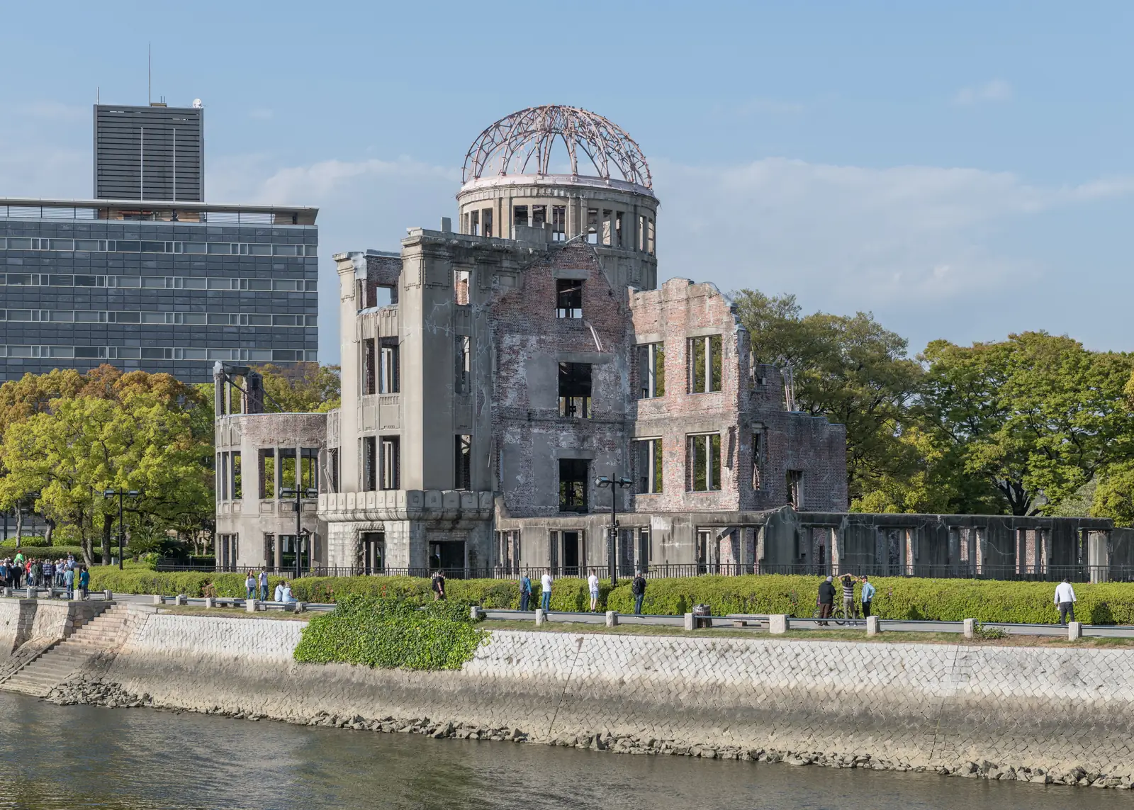 South view of the Atomic Bomb Dome across the Motoyasu River in April, with visitors on the riverside path