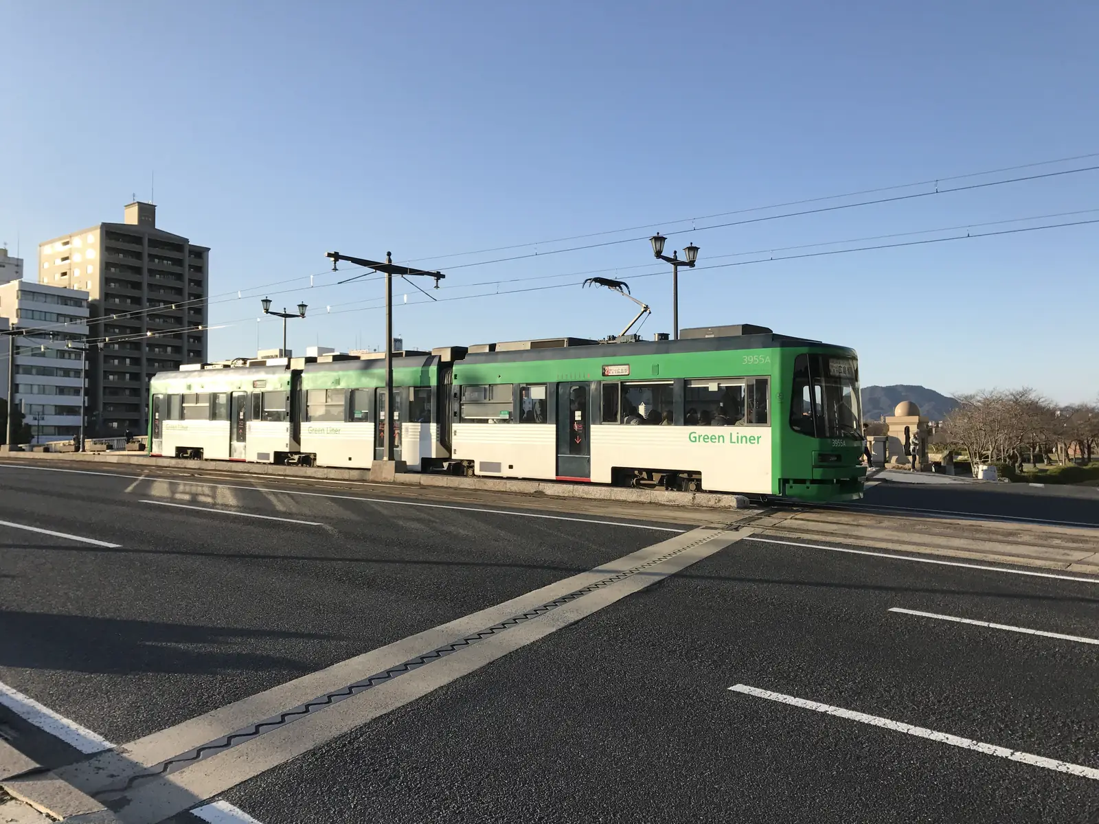 A green Hiroden tram crossing Aioi Bridge, a short walk from the Atomic Bomb Dome