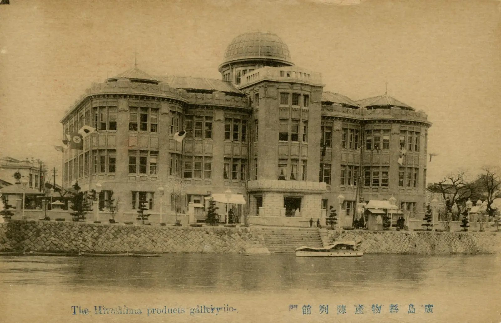 Sepia postcard of the Hiroshima Prefectural Commercial Exhibition Hall, an ornate building with a large green dome, seen across the river before 1945