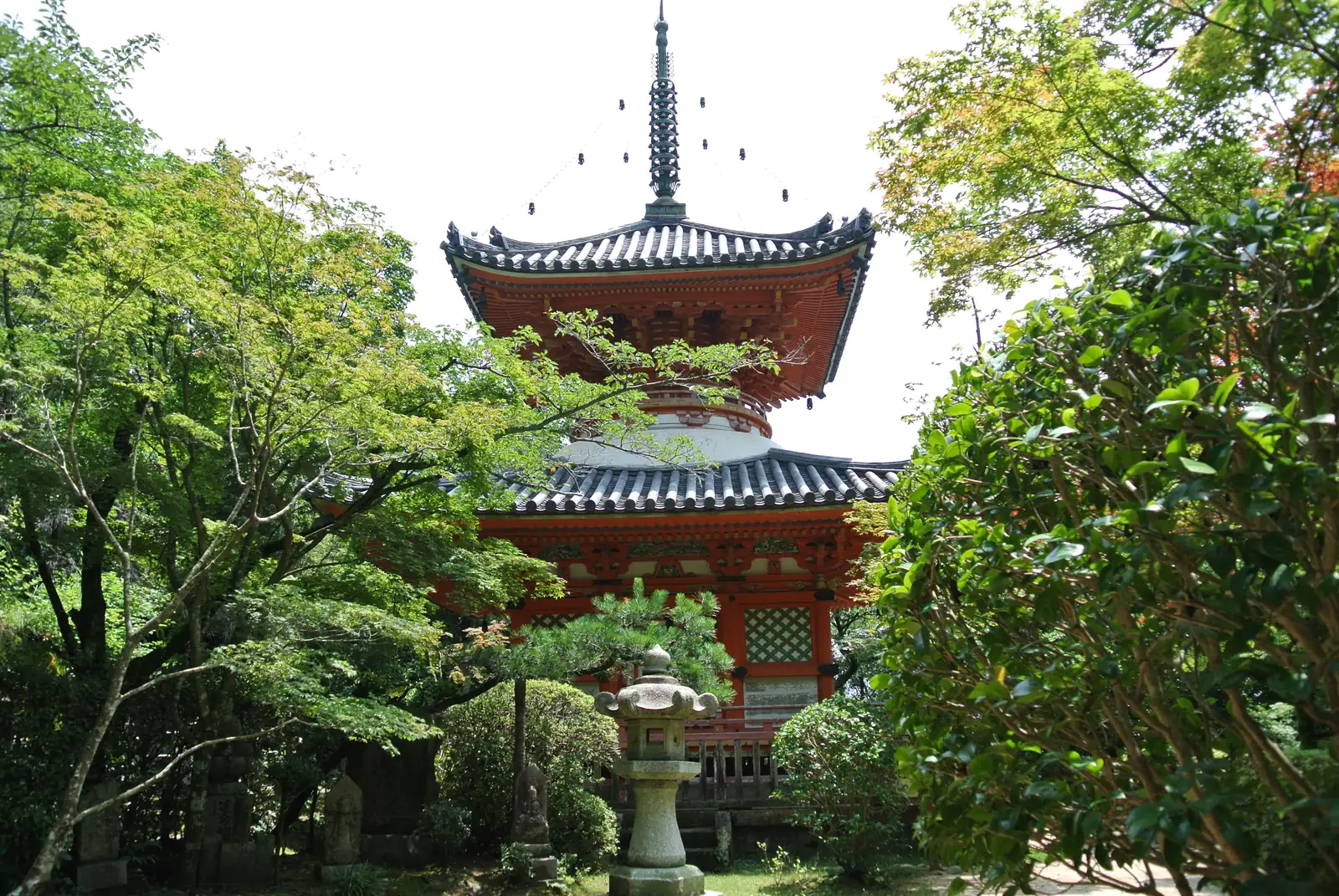 The vermilion two-storey pagoda at the entrance to Mitaki Temple among trees