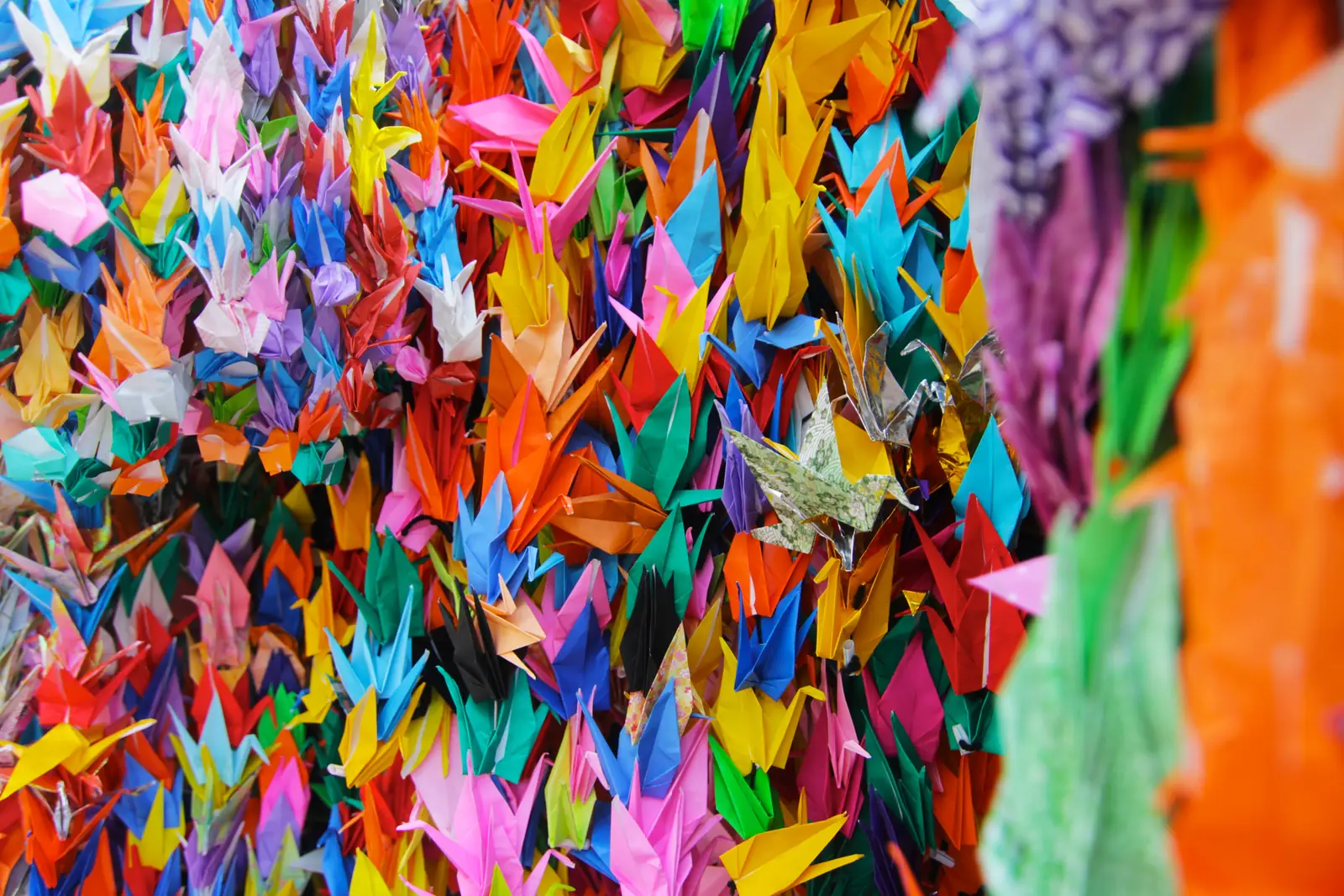 Strings of folded paper cranes in many colours hanging together at the Children's Peace Monument
